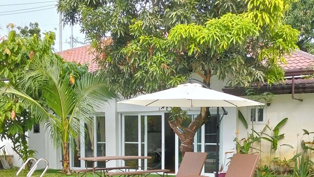 A swimming pool with lounge chairs and a covered seating area.