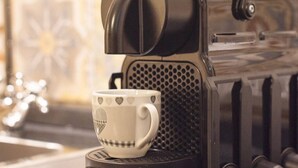 Une machine à café avec une tasse de café posée sur le bac d’égouttement.