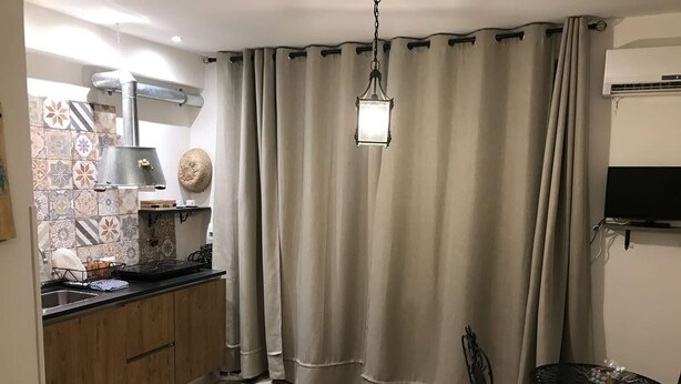 Une cuisine avec des meubles de rangement en bois, une cuisinière et un coin repas comprenant une table et des chaises.