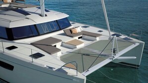Un yacht moderne doté d’un pont spacieux, de coins salon confortables et offrant une vue dégagée sur l’eau.