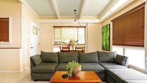 A living room with a sectional sofa, a wooden coffee table, and a dining area with a table and chairs.