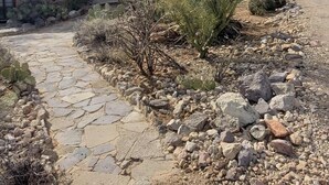 Un bâtiment en pierre avec un chemin pavé menant à une porte.