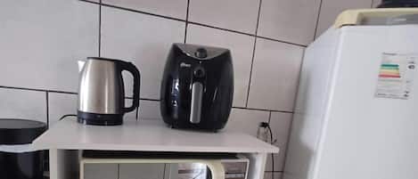 A kitchen with a microwave, a coffee maker, and a refrigerator.