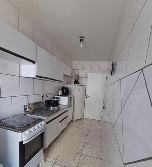 Refrigerador, microondas, utensilios de cocina, mesa de comedor