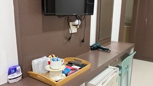 A hotel reception area with a flat-screen TV mounted on the wall, a wooden tray with cups and remote controls, a small refrigerator, and a trash bin. - Lovely 1-bedroom private bungalows at riverside resort with AC and full kitchen. (ตำบล เกาะลันตาใหญ่)
