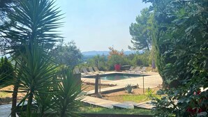 A pool area with lounge chairs and a view of the mountains. - Maison piscine proche Alpilles (Noves)