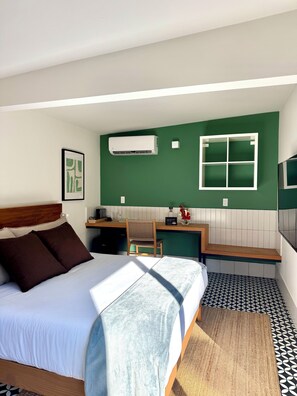 A hotel room with a bed, a desk, an air conditioner, a window, and a patterned floor. - oolena Unique Studio w/private terrace (Ciudad de México)
