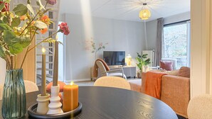 Un salon moderne avec une table en bois foncé, un téléviseur et un canapé.