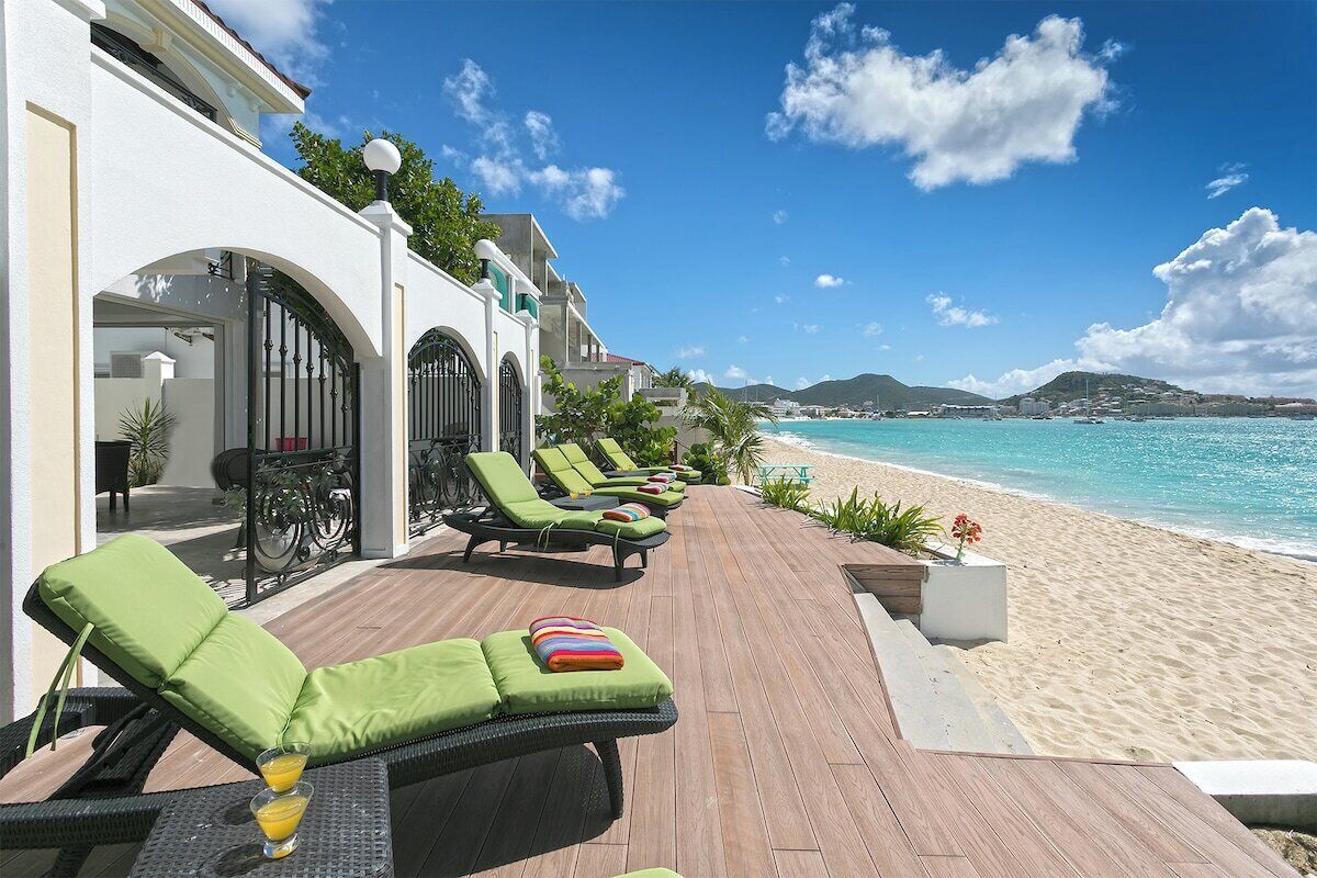 A beachside lounge area with sun loungers and a wooden deck overlooking the ocean.
