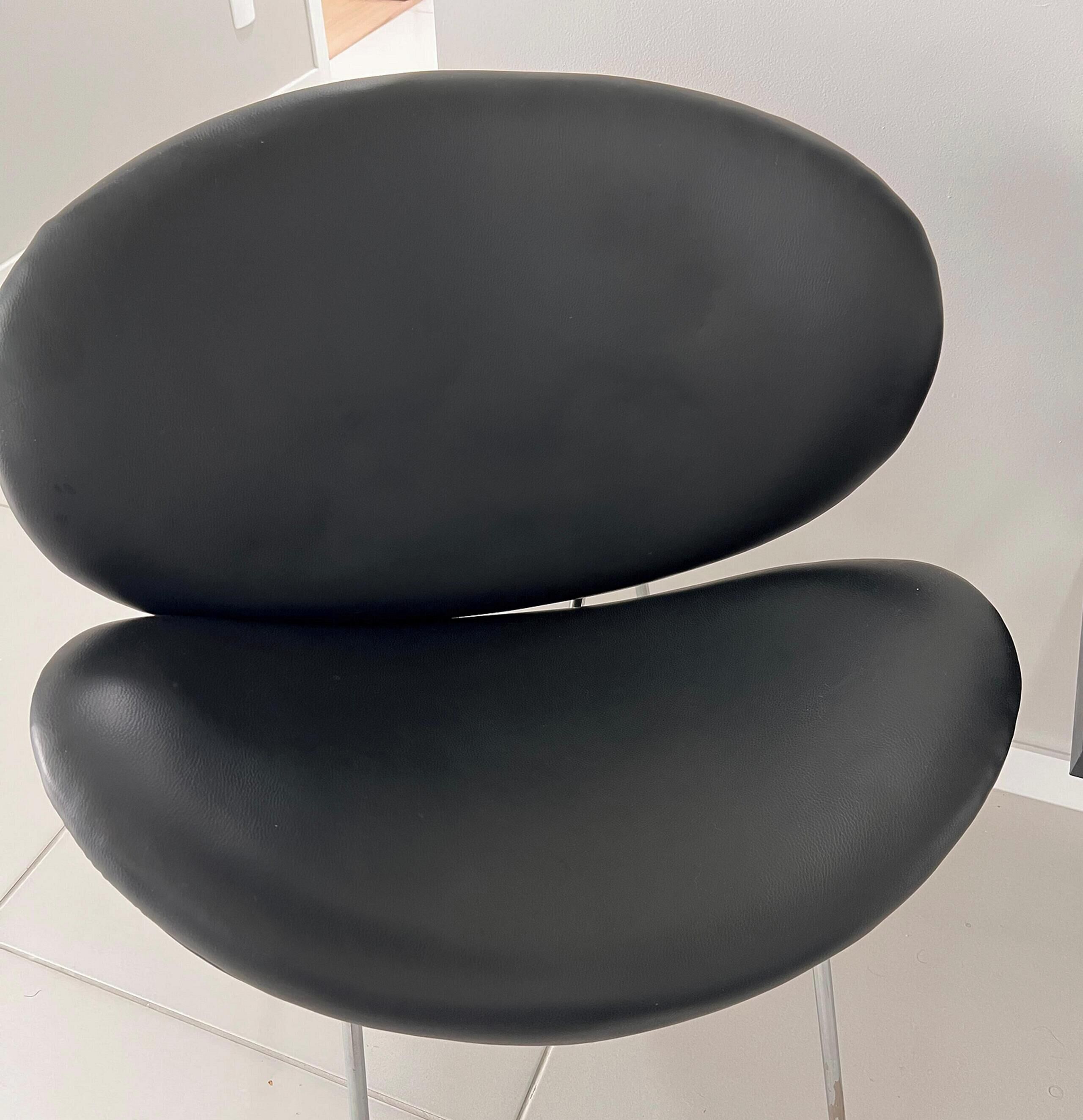 A black, modern chair with a smooth, glossy finish.