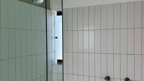 A modern bathroom with a glass shower enclosure, white tiled walls, and a visible window. - oolena Tiny and Peaceful Nest w/private terrace (Ciudad de México)