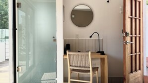 A room with a bed, a desk with a chair, a round mirror, and a wooden door. - oolena Tiny and Peaceful Nest w/private terrace (Ciudad de México)