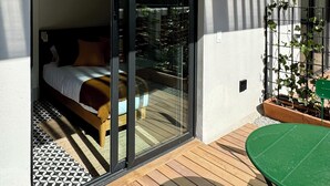 A modern room with a large sliding glass door leading to a wooden deck. - oolena Tiny and Peaceful Nest w/private terrace (Ciudad de México)