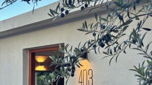 A modern building with a number '403' on the wall, a wooden door, and a view into a room with a bed and a nightstand. - oolena Tiny and Peaceful Nest w/private terrace (Ciudad de México)
