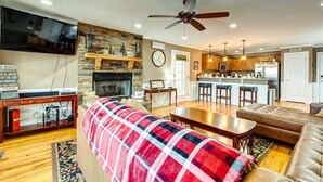 A cozy living room with a fireplace, a television, and a dining area.