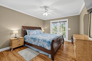 A bedroom with a bed, nightstand, dresser, and a ceiling fan. - Lake Sinclair 4BR | Private Dock & Game Room (Sparta)