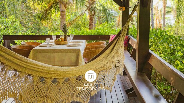 A hammock table set up on a wooden deck with a view of lush greenery. - Kite House - Ibiraquera - SC (Imbituba)