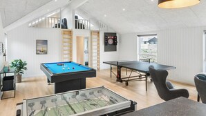 Une pièce équipée d’un baby-foot, d’une table de billard et d’un jeu de fléchettes.