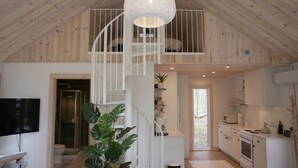 Un interior moderno con una escalera de caracol, una cocina y una sala de estar.