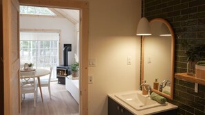 Un baño moderno con un espejo grande, un lavamanos y una ventana.