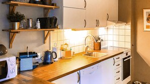 A kitchen with white cabinets, a wooden countertop, a sink, and various kitchen appliances. - Awesome apartment in Lindesnes with WiFi (Lindesnes)