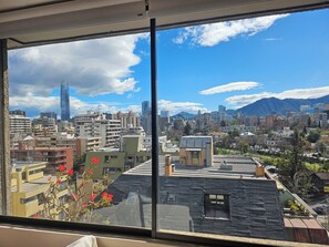 A cityscape with a prominent skyscraper, a variety of building styles, and a mountainous backdrop. - Apartment in an unbeatable location, spectacular views (Providencia)