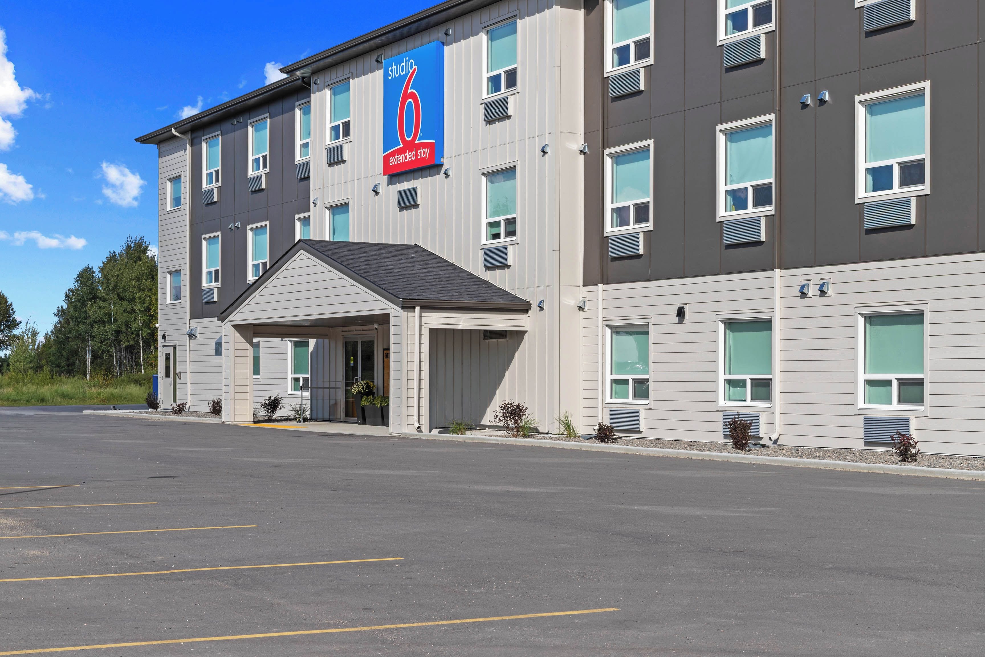 Un hôtel à plusieurs étages, doté d’une entrée couverte et d’un parking.