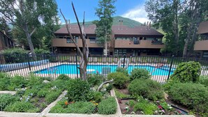 A swimming pool surrounded by a wooden deck, with a bench in the foreground. - Cozy 1-bedroom condo seconds from bus line in East Vail, perfect for getaways. (Vail)