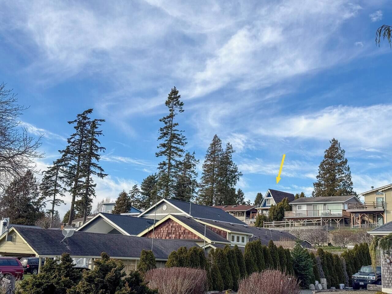 A residential area with houses, trees, and a clear sky.