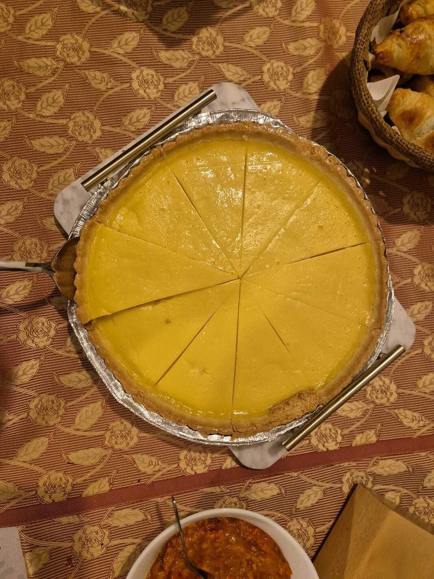 A pie with a golden crust on a table with a floral tablecloth.