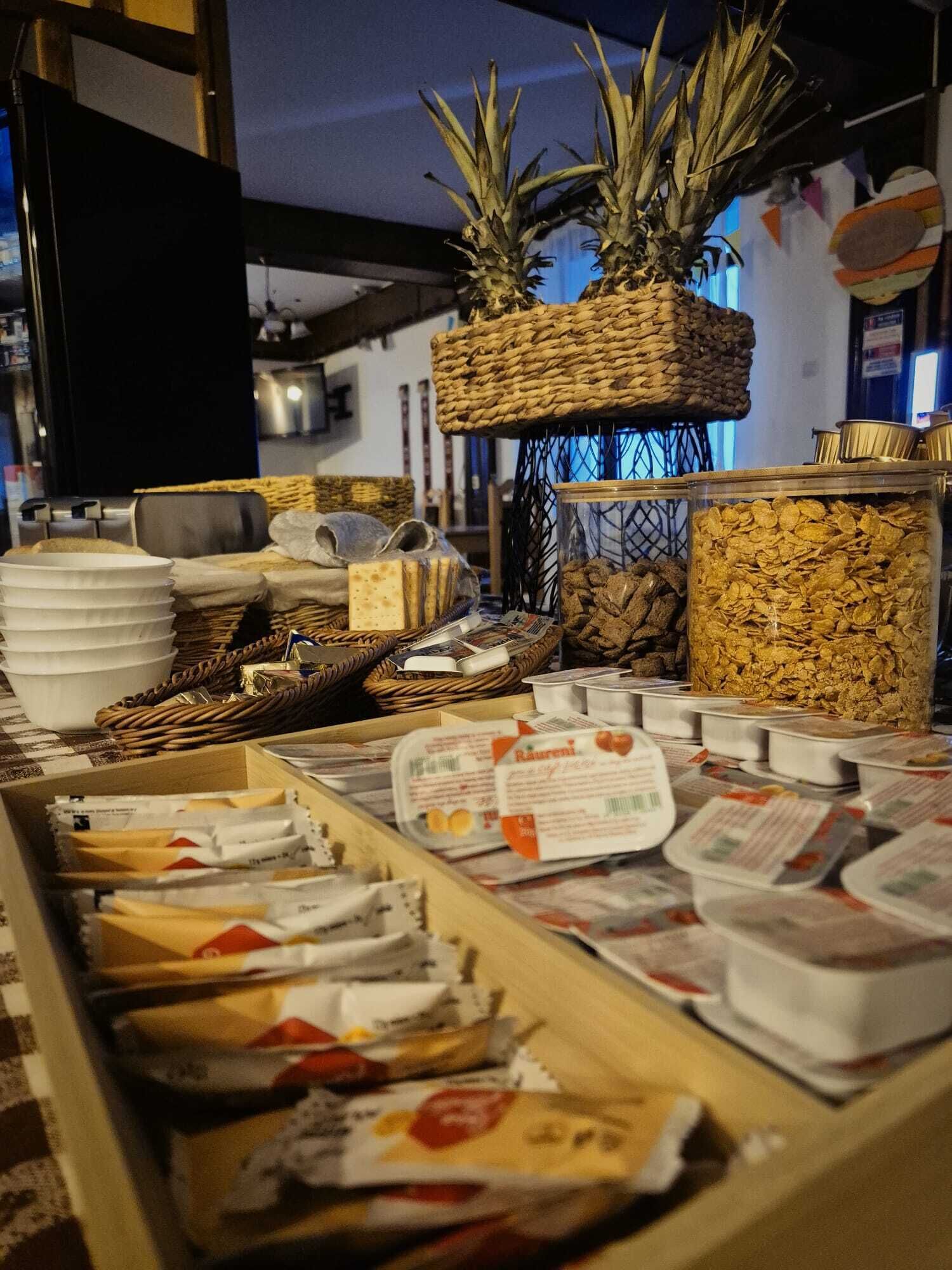 Un buffet proposant une variété d’aliments, notamment du pain, du fromage et des céréales.