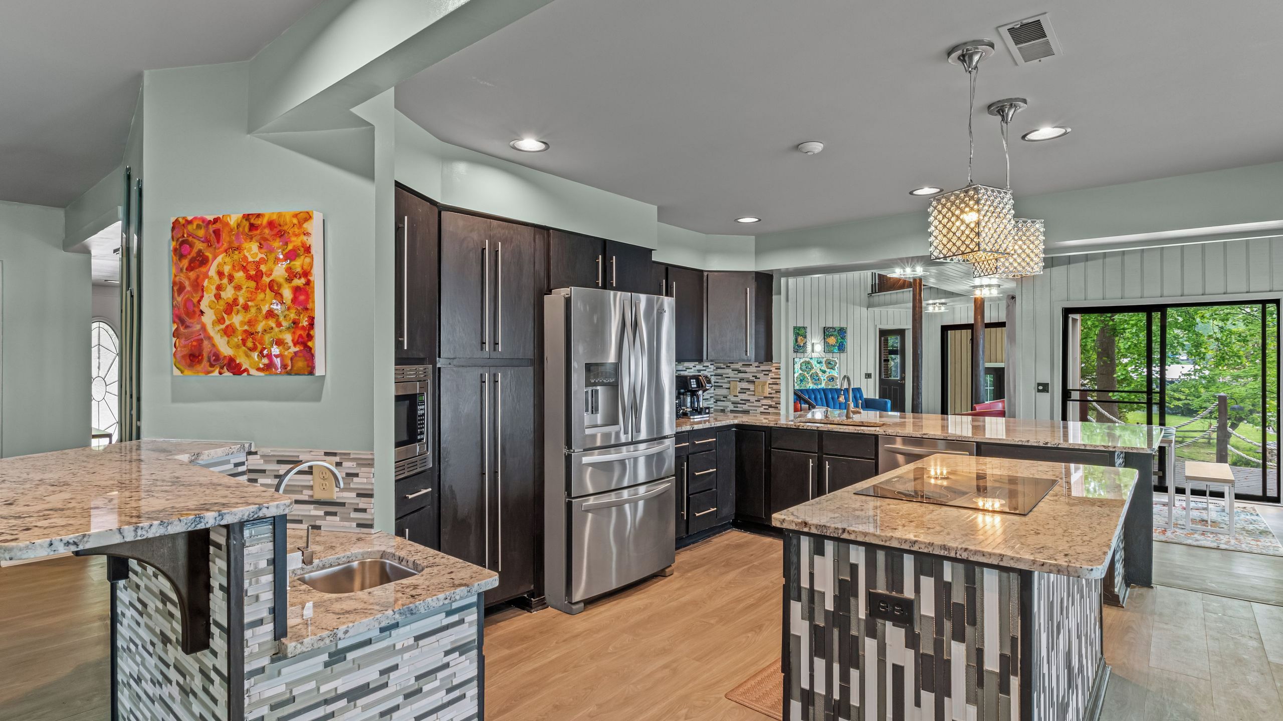 A modern kitchen with granite countertops, stainless steel appliances, and a large island.