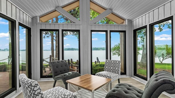 A room with large windows, a wooden table, and two patterned chairs. - Waterfront Stay w/ Canoes, Deck, Game Room & Lake Views Near Mooresville Renwick Cove by Avantstay (Mooresville)