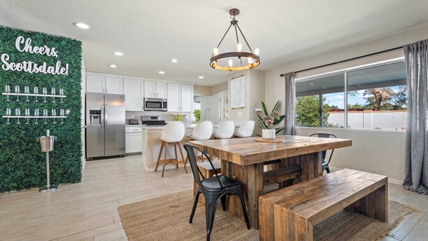 A modern kitchen with white cabinets, a stainless steel refrigerator, and a built-in microwave. - Heated Pool, Fire Pit, Games & Outdoor Dining Just Minutes to Old Town Drift House by Avantstay (Scottsdale)