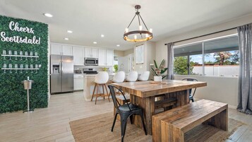 Una cocina moderna con armarios blancos, un refrigerador de acero inoxidable y un microondas integrado.