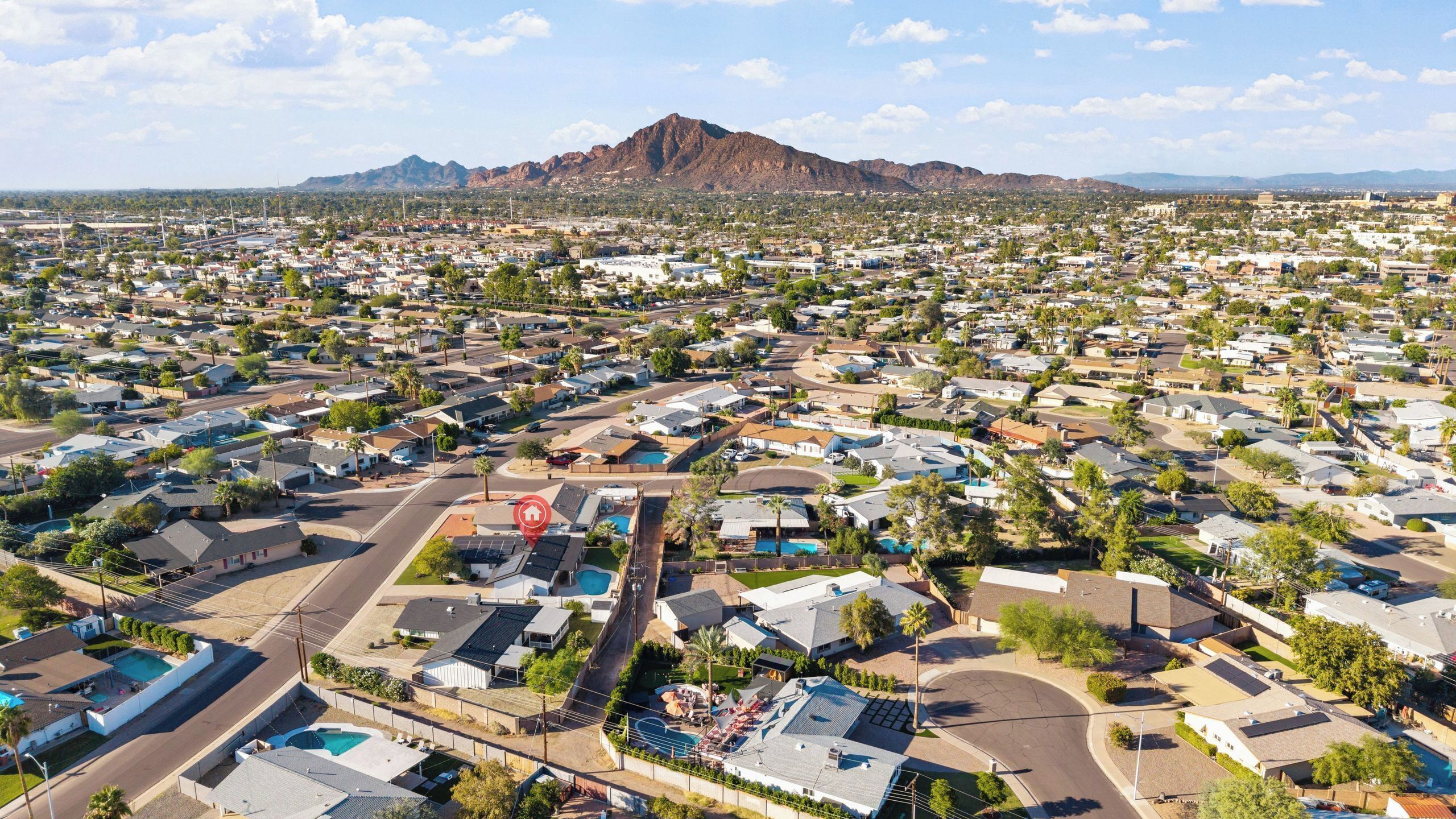 A residential area with houses, roads, and a mountain in the background.