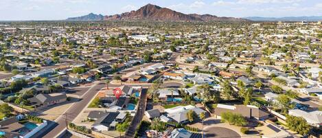A residential area with houses, roads, and a mountain in the background.