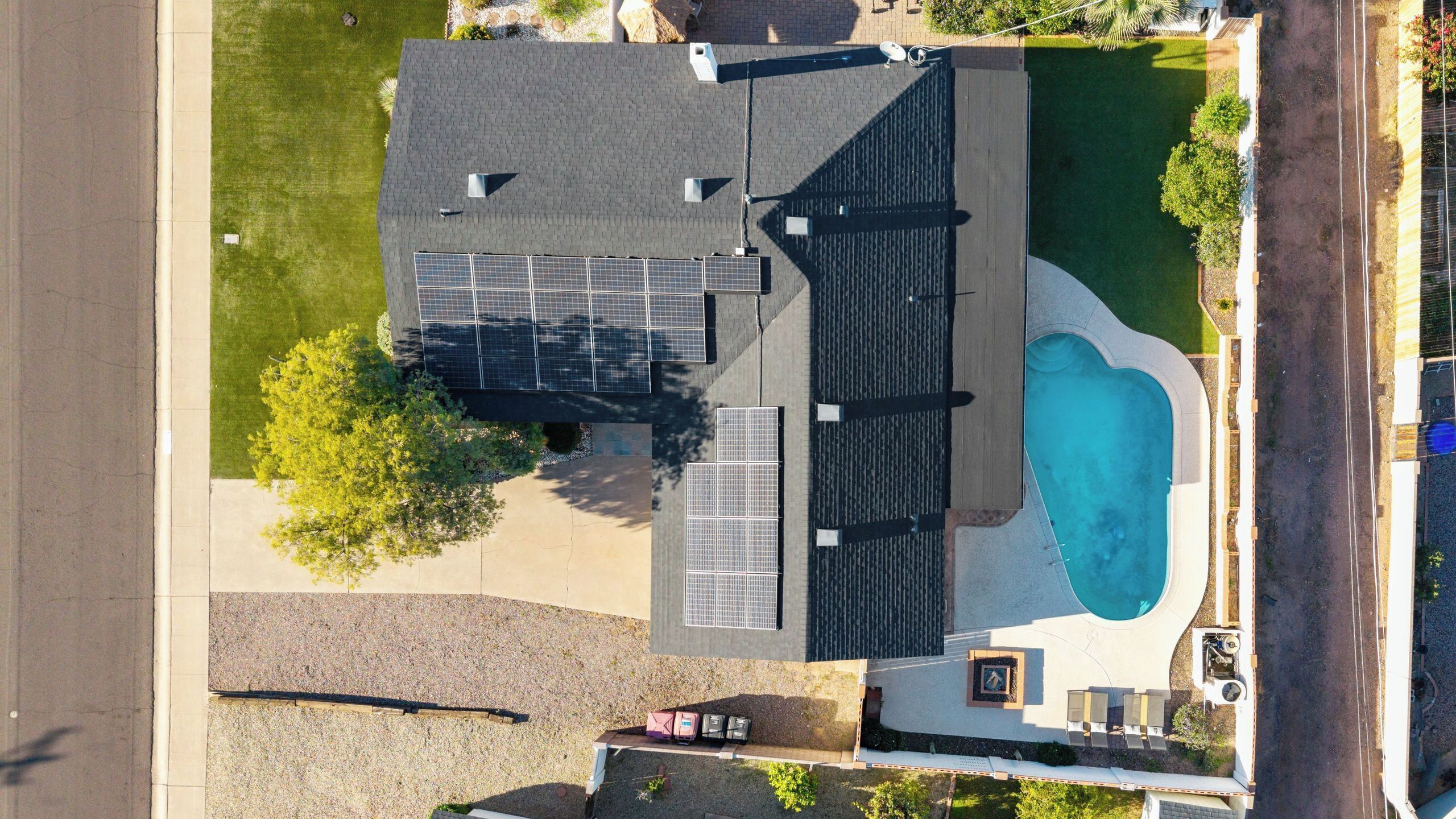 Una propiedad residencial con piscina, paneles solares y entrada para vehículos.