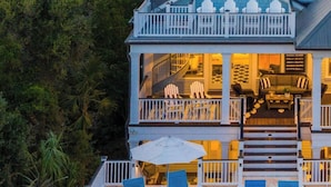 A large, two-story house with a balcony, a pool, and lounge chairs. - Beachside Stay With Pool, Two Decks, Rooftop Lounge & Steps to Front Beach IOP Beachhouse by Avantstay (Isle of Palms)