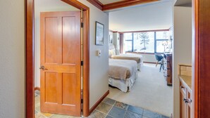 Un couloir mène à une chambre dotée de deux lits, d’un coin cuisine et d’une salle de bain.