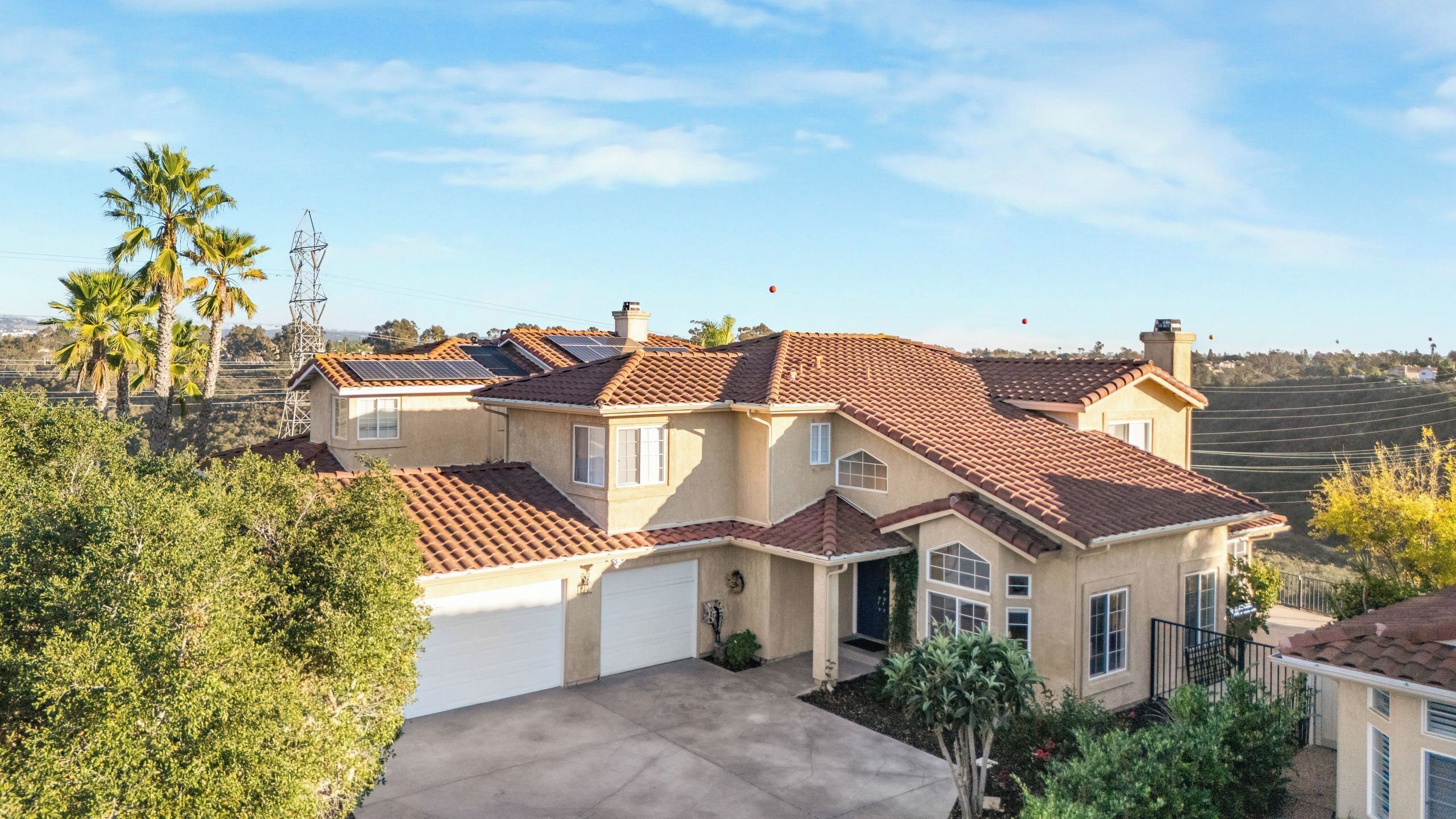 A large, single-story house with a tiled roof, a garage, and a well-maintained lawn.