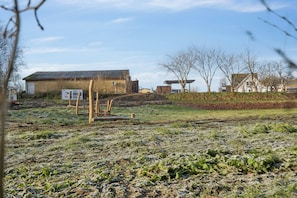 A rural landscape with a building, a wooden structure, and a signboard. - Calm holiday home with great outings (Kruså)