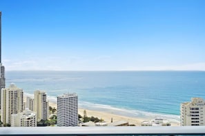 Eine Küstenstadt mit Hochhäusern, einem Strand und blauem Himmel.