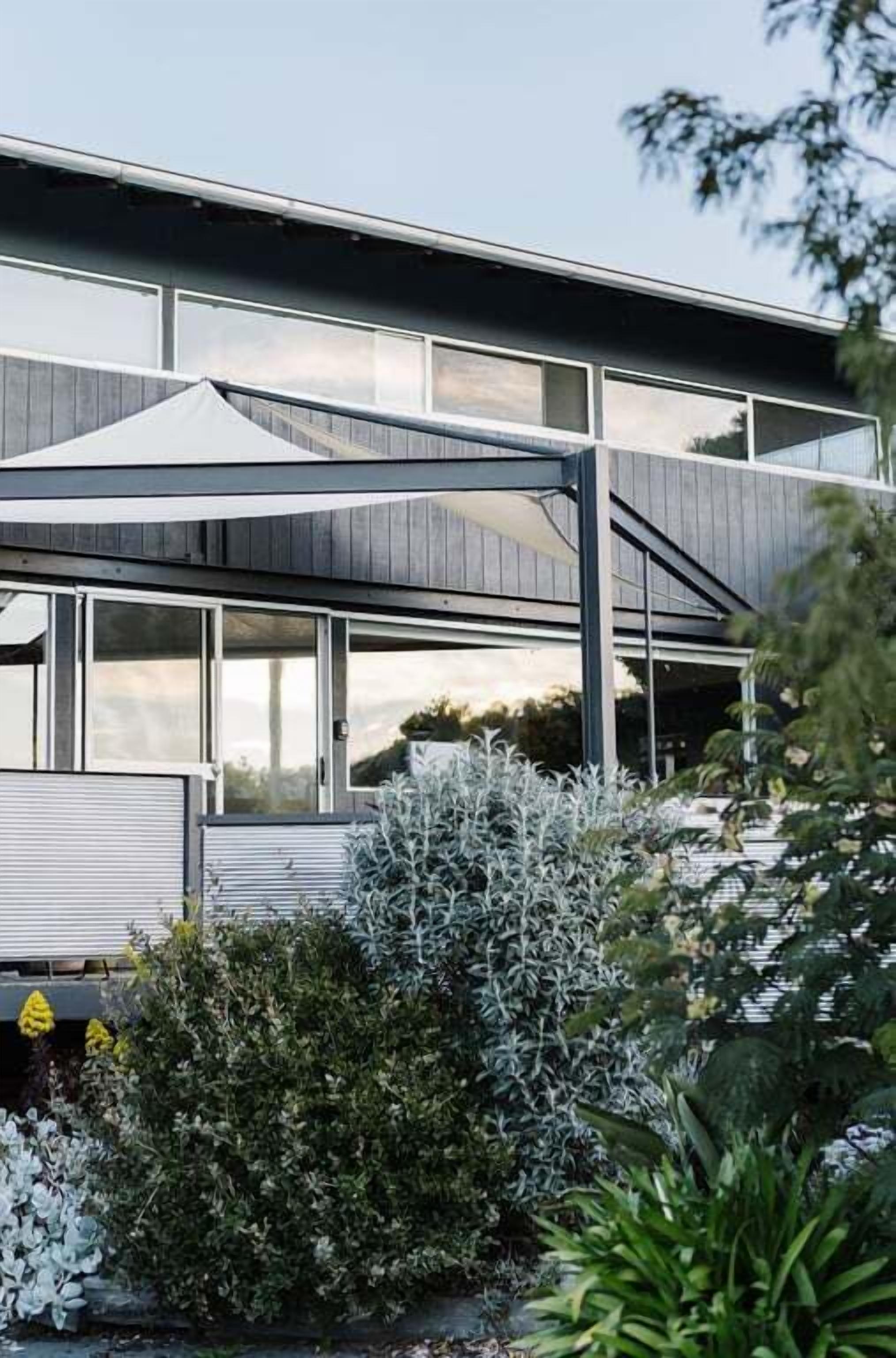 A modern building with large windows and a covered outdoor area.