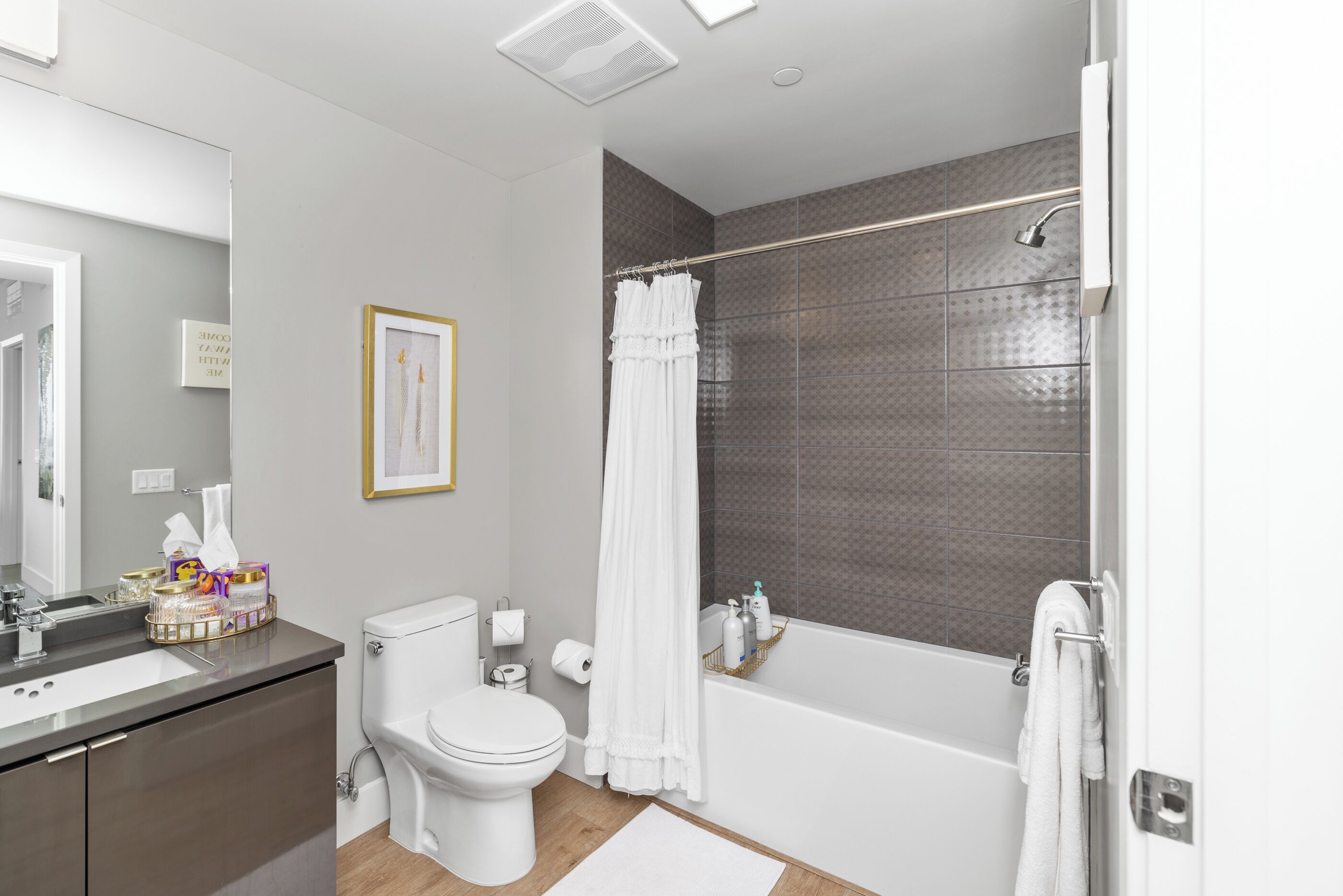 A modern bathroom with a toilet, sink, and bathtub.