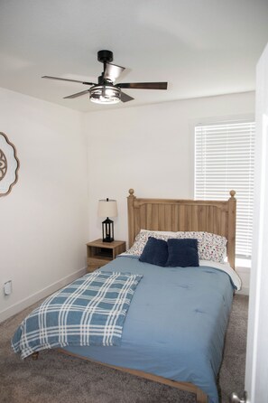 A bedroom with a bed, a nightstand, a lamp, a ceiling fan, and a window with blinds. - Enjoyable 4-bedroom house with AC in charming Taylor.  (Taylor)