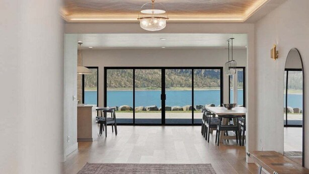 A spacious room with a large sliding glass door leading to a scenic outdoor view.