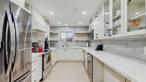 A modern kitchen with stainless steel appliances, white cabinetry, and a tiled backsplash. - Balcony & Pool Access! Extended Stay in Scottsdale (Scottsdale)