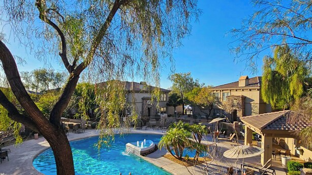 A pool area with a circular pool, lounge chairs, and a pergola. - Balcony & Pool Access! Extended Stay in Scottsdale (Scottsdale)