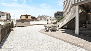 Ein Wohngebiet mit Schotterauffahrt, Holzzaun und Häusern unterschiedlicher Architektur.